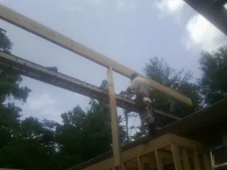 Carpenter setting a ridge beam over a new addition frame — Ice Dam Removal by Roofing Brothers in Line Lexington