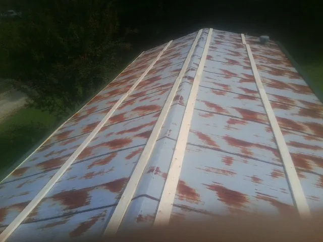 Rusted metal roof panels with new wood purlins before replacement — Storm Damage Roof Repair in Line Lexington by Roofing Brothers