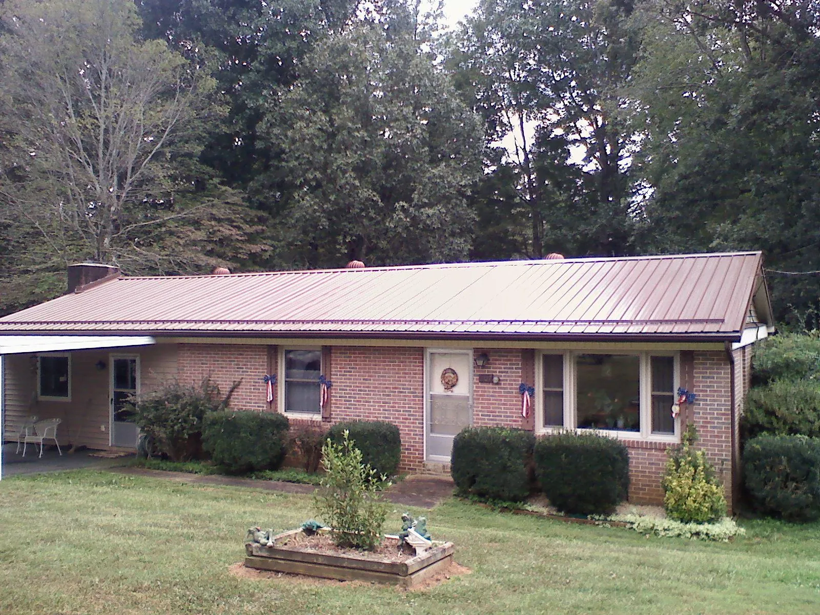 Bronze metal roof on a brick ranch home with a carport in Line Lexington