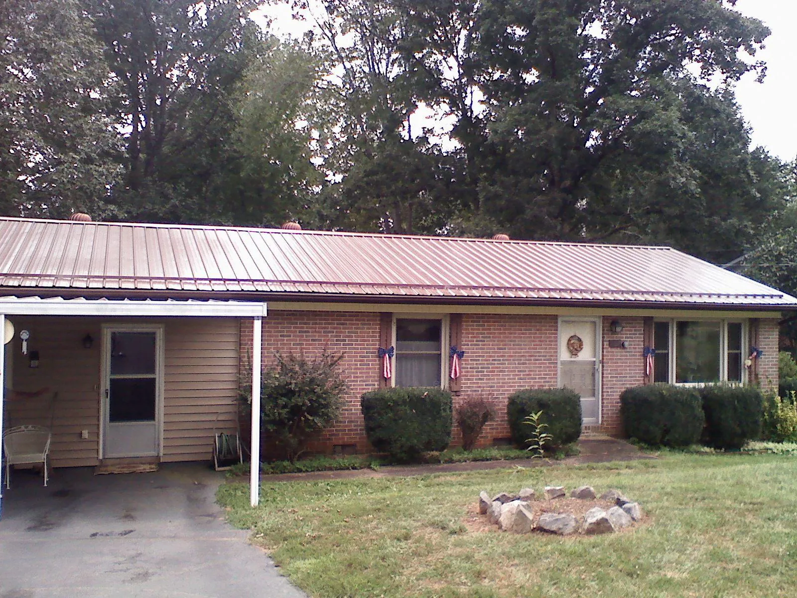 Bronze metal roof and carport on a brick ranch home — Roof Repair work by our crew in Line Lexington